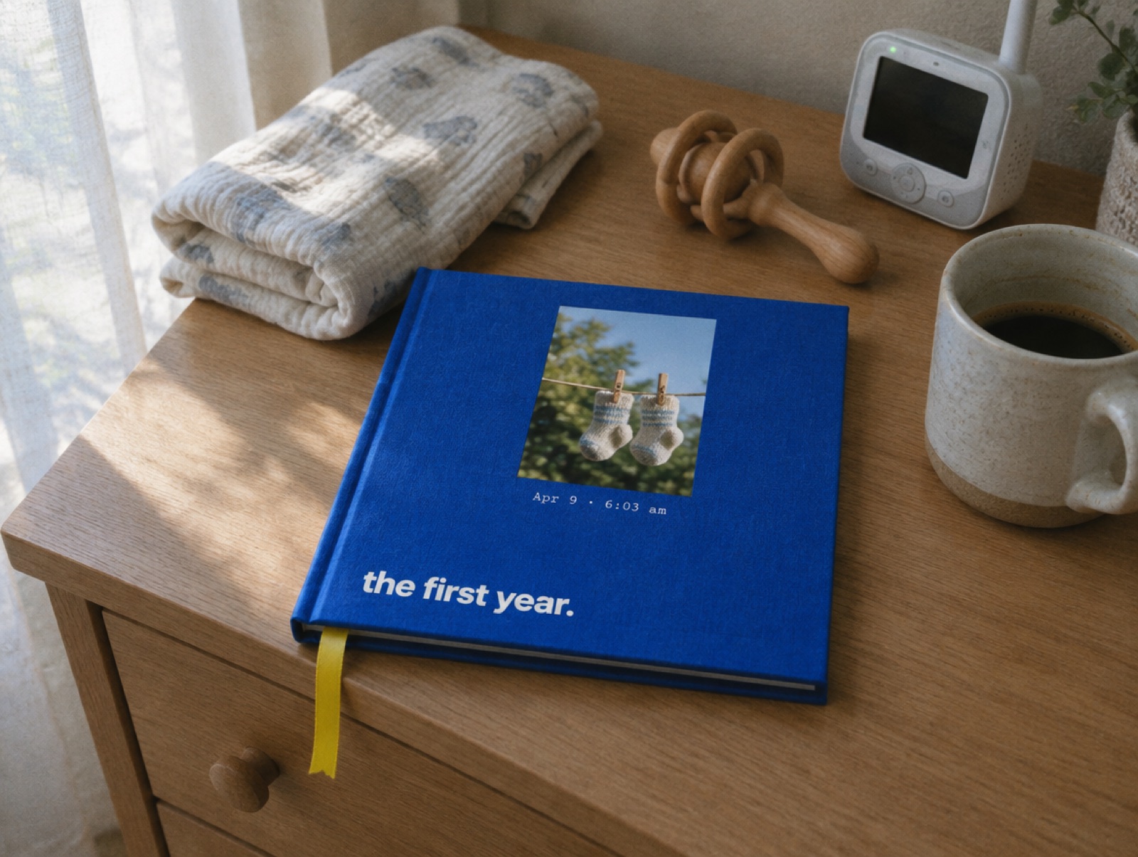 A cobalt book titled the first year on a nursery dresser