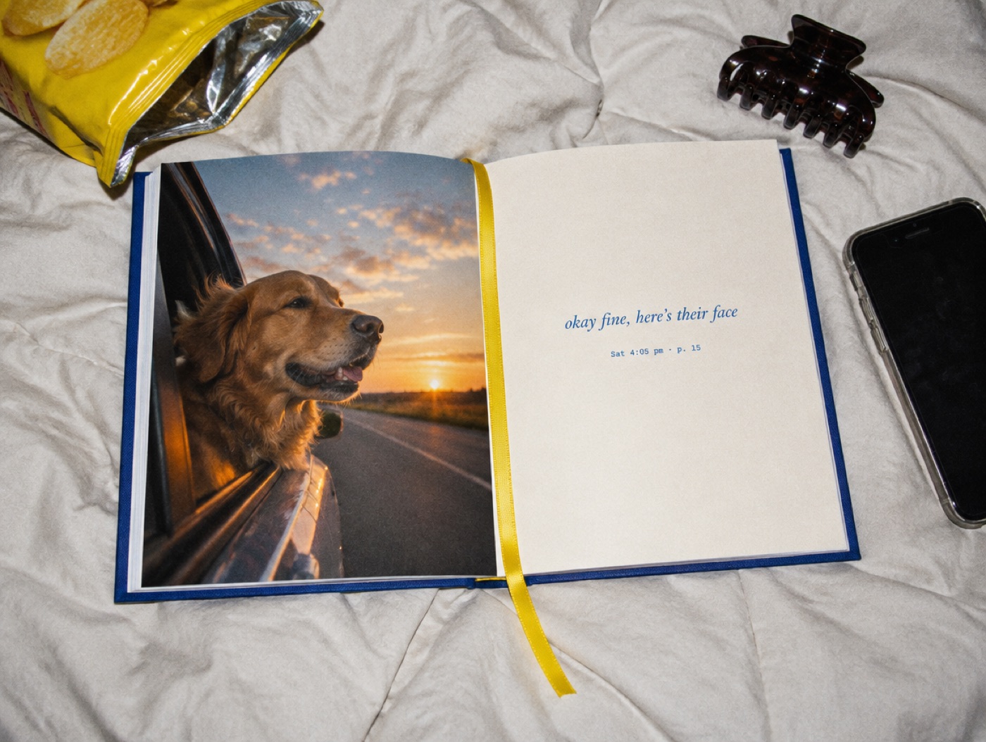 An open book on a duvet. A full page photo of a dog on the left, a short caption and a timestamp on the right.